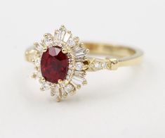 a red and white diamond ring on a white surface