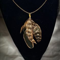 a necklace with feathers hanging from it on a mannequin