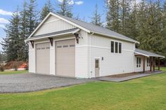 a two car garage sits in the middle of a yard with lots of grass and trees