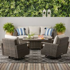 an outdoor living area with wicker furniture and potted plants on the side wall