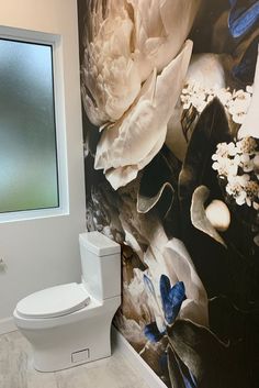 Black floral wallpaper in bathroom on the wall behind a white toilet