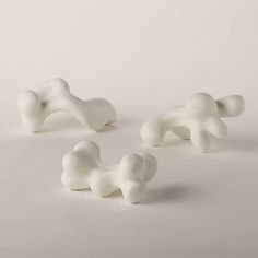 three small white figurines sitting next to each other