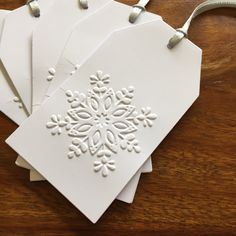 four snowflake tags on a wooden table