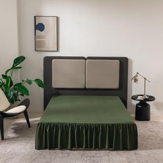 a bed with a green bedspread in a white room