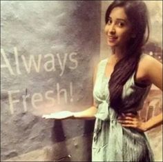 a woman standing in front of a chalkboard with writing on it that says always fresh