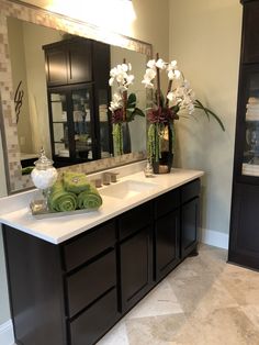 a bathroom with two sinks and large mirrors in it's center area, along with towels on the counter