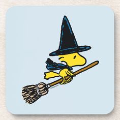 a cartoon dog wearing a witches hat and holding a broom on a blue background beverage coaster