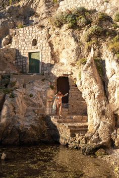 there is a woman standing at the entrance to a cave