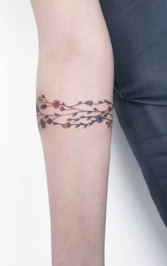 a woman's leg with a tattoo on it and an arm that has flowers growing out of it