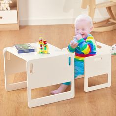 a baby sitting in a play table with blocks on the bottom and one leg up