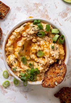 an image of a bowl of food with bread and green onions on the side for garnish