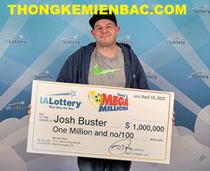 a man holding a large check for $ 1, 000 in front of a backdrop