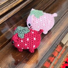 two crocheted stuffed animals sitting on top of a wooden bench