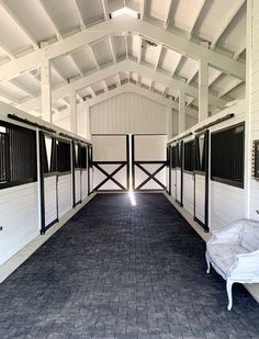 the inside of a horse barn with white walls and black shutters