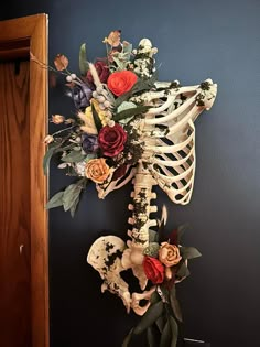 a skeleton with flowers in it hanging on the wall