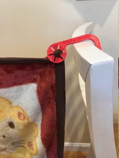 a close up of a stuffed animal on a chair with a red handled wrench