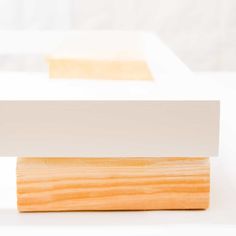 a piece of wood sitting on top of a white table next to another piece of wood