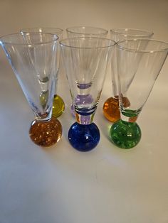 four different colored glass vases sitting next to each other