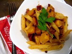 a white plate topped with french fries covered in sauce and garnished with parsley