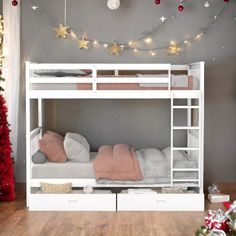 a white bunk bed sitting next to a christmas tree in a room with red and gold decorations