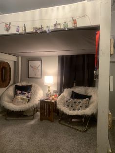 a loft bed with two chairs and a table in the corner next to each other