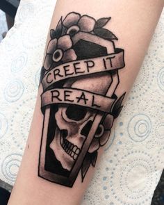 a black and white photo of a skull with a banner on it's arm