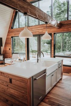 a large kitchen with an island in the middle and lots of windows on both sides