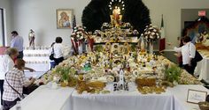 several people standing around a table with many items on it, including figurines