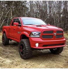 a red dodge ram truck parked in the woods