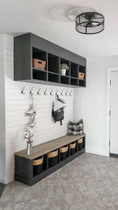 a white and gray entryway with black cubbys