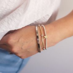 This bundle includes a silver meet me in the middle bangle that can be personalized with a name, a silver beaded bracelet accented with a gold-filled initial and a two tone "bangle" like stretch bracelet Bracelet available in three sizes Small/Medium: approximately 6.5 inches Medium/Large: approximately 7 inches Large/X-Large: approximately 8 inches ENTER NAME FOR BANGLE IN CUSTOMIZE BOX ABOVE Mixed Metal Bracelet Stack, Mixed Metal Bracelet, Metal Bead Bracelet, Mixed Metal Bracelets, Silver Beaded Bracelet, Silver Bead Bracelet, Metal Bracelet, Jewelry Inspo, Metal Bracelets