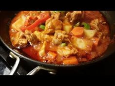 a pan filled with meat and vegetables on top of a stove