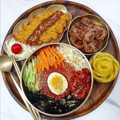 a wooden plate topped with lots of different foods and meats on top of it