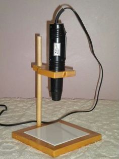 a black and white object sitting on top of a wooden stand next to a wall