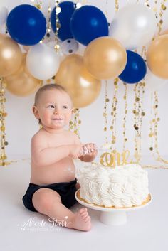 a baby sitting in front of a cake