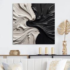 a living room with white couches and black and white artwork hanging on the wall