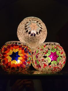 three glass vases sitting on top of a table next to each other in front of a black background