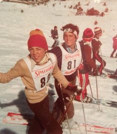 a group of people riding skis on top of snow covered ground next to each other