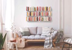 a living room filled with furniture and lots of books on the shelves above it's couch