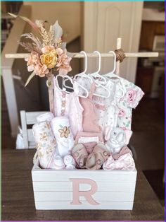 a wooden box filled with baby items on top of a table next to a flower