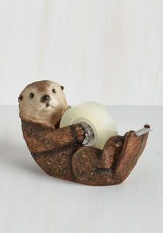 two otters in a wooden boat with tape dispensers on the sides