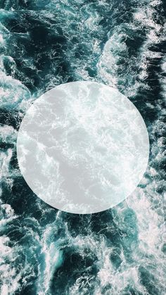 a white circle floating in the middle of some blue ocean water with foamy waves