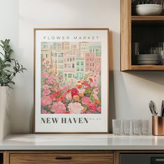 a kitchen counter with flowers in the foreground and a poster on the wall above it