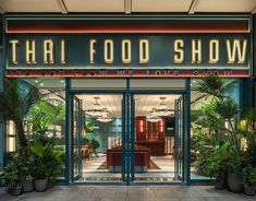 an entrance to a restaurant with plants and potted plants