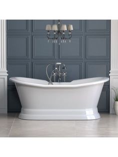 a white bath tub sitting under a chandelier