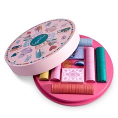 an assortment of crafting supplies on a pink tray