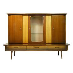 an old fashioned wooden cabinet with glass doors