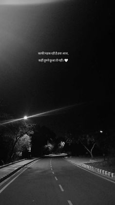 a black and white photo of a road at night with the words, one way to the moon shines