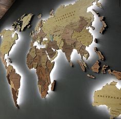 a wooden world map is shown on the wall in an empty room with lights around it