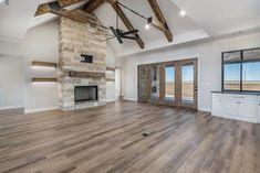 an empty living room with wood flooring and exposed beams on the ceiling is shown